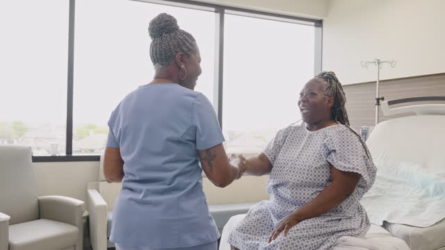 Mature female patient greets female nurse with handshake