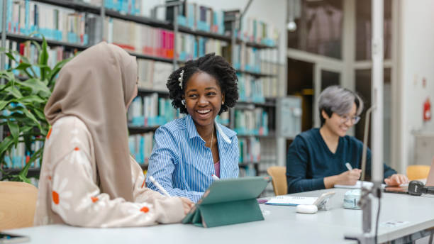istock Multiethnic group of students sitting in a library and studying together 1498724459