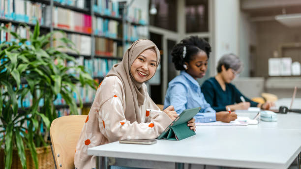 istock Multiethnic group of students sitting in a library and studying together 1498725437