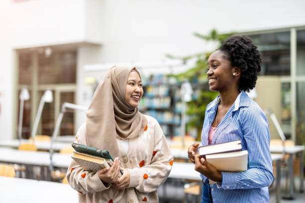 Multiethnic group of students sitting in a library and studying together