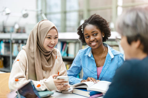 istock Multiethnic group of students sitting in a library and studying together 1498726080