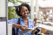 Black female student reading a book in a library