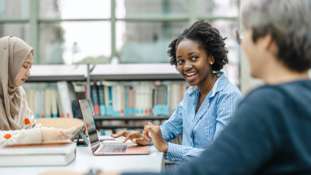 istock Multiethnic group of students sitting in a library and studying together 1498726190