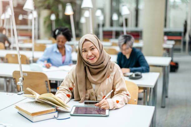 istock Multiethnic group of students sitting in a library and studying together 1498726596