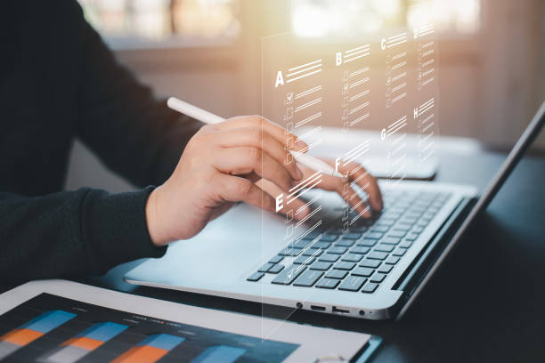 istock Businessman using a laptop and Taking an assessment, questionnaire, evaluation, online survey online exam Choosing the right answer in exam by filling out the online survey form,Answer  test questions 1498726606