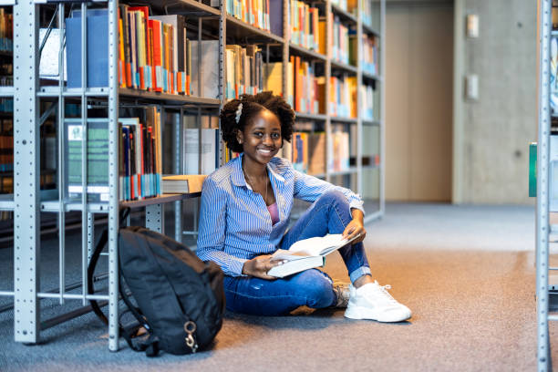 istock Black female student reading a book in a library 1498727468