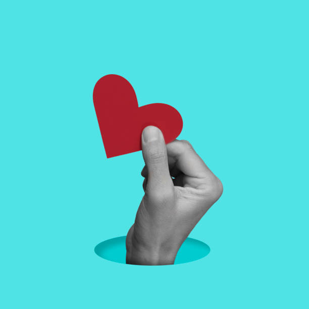 istock hand in black and white holding a red heart 1498728407