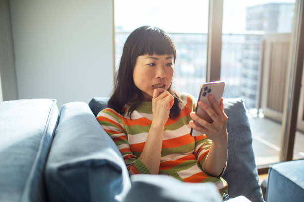 istock Young Japanese Woman using a smart phone at home 1498729839