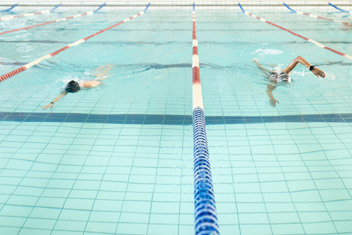 Freestyle swimmers compete in a close race during a summer swim meet.