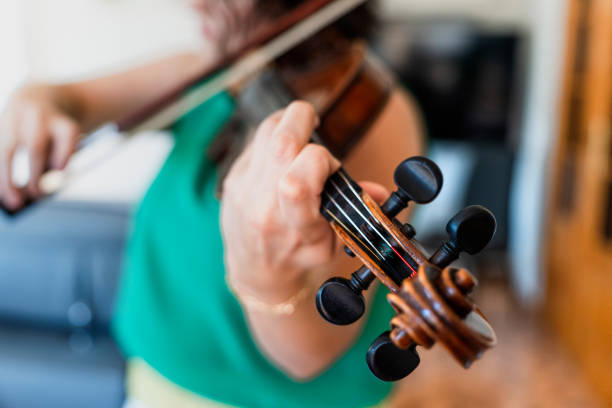 istock Harmonious Reflections: Professional Middle-aged Violinist Performing at Home 1498734525