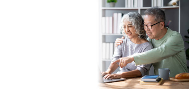 istock Mature old couple spending their time together using laptop computer, having a great time in the living room. 1498735346