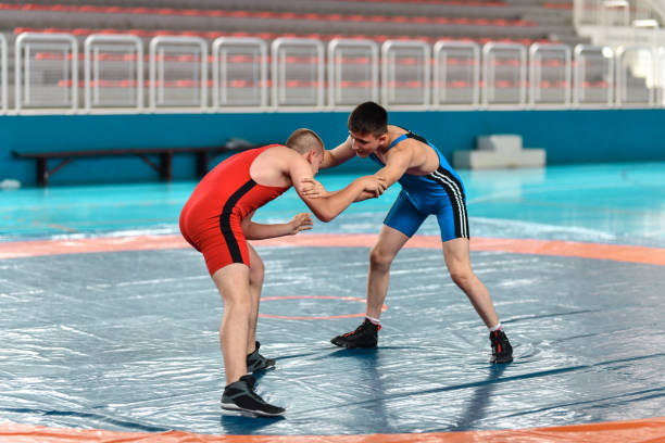 Blue Vs Red During Wrestling Match Blue Vs Red During Wrestling Match wrestling sport stock pictures, royalty-free photos & images