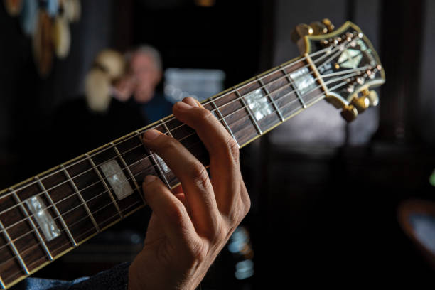 istock Closeup of hand playing guitar neck 1498740302