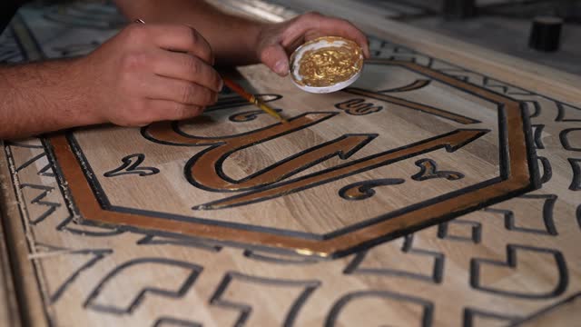 Close up shot of Arabic Calligraphy Painting done by a man