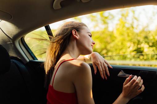 Young woman enjoys the backseat ride in a vehicle