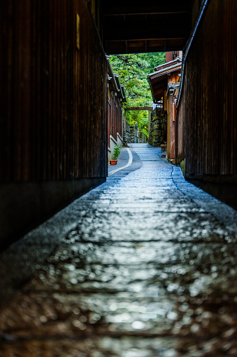 A narrow stone-paved alley that leads to a backstreet in Kyoto