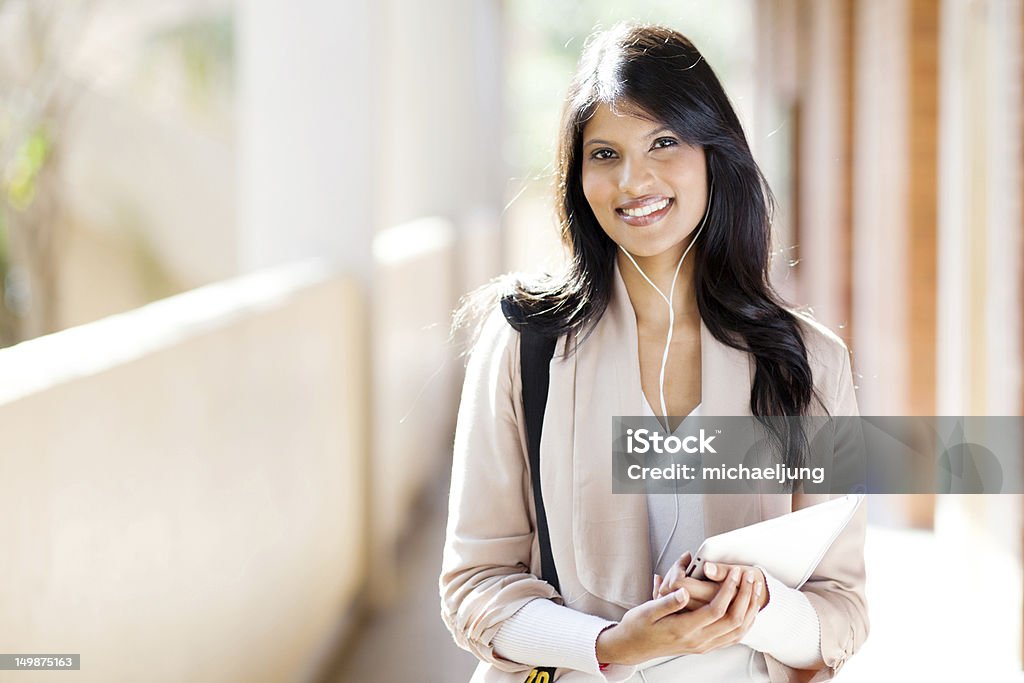 female university student using tablet computer listening music happy female university student using tablet computer listening music on campus Digital Tablet Stock Photo