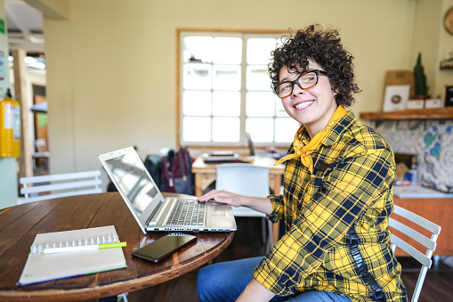 Portrait of a young woman using laptop at a coffee shop