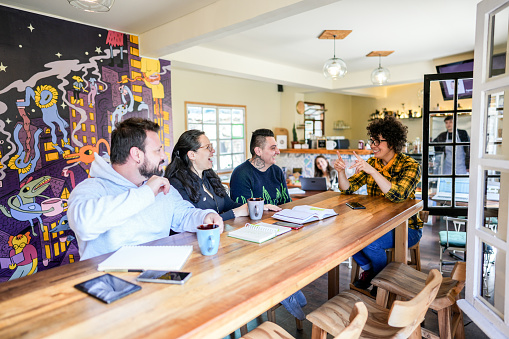 Colleagues doing a language sign class at a coffee shop