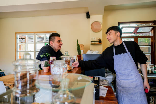 istock Waiter talking and serving customer at a coffee shop 1498753756
