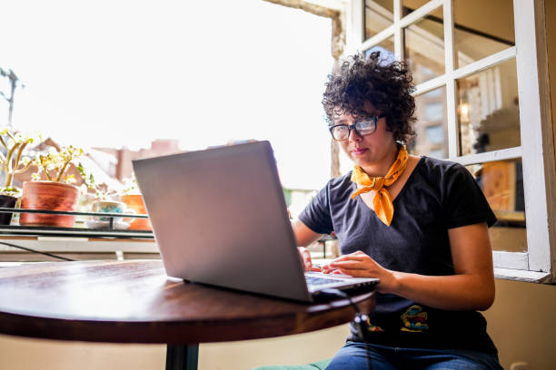 istock Young woman using laptop at a coffee shop 1498753769