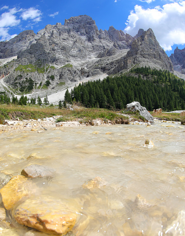 pure clear stream water and the background of European Alps called Dolomites in northern Italy