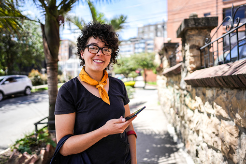Portrait of a young woman using mobile phone in the city