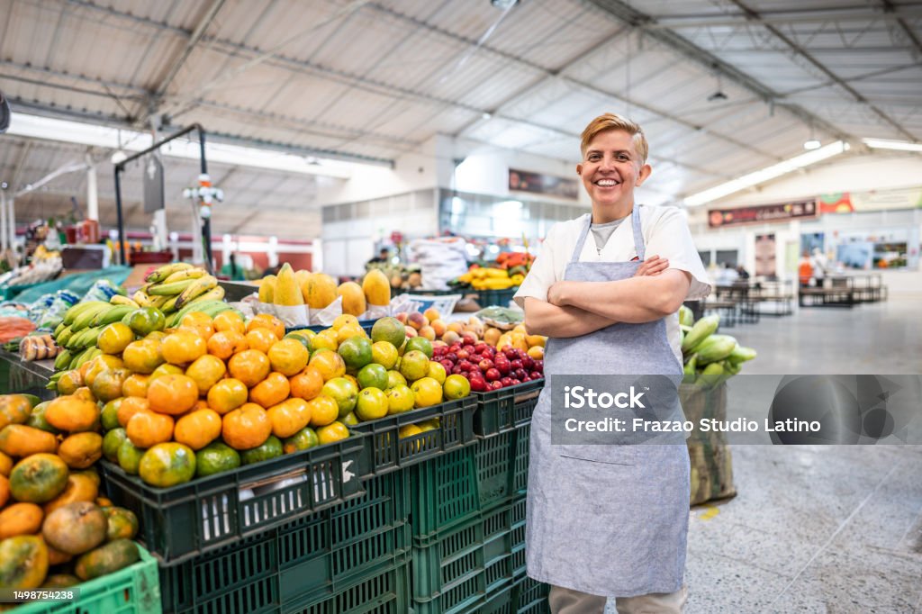 Portrait of a mature female retail clerk working at a greengrocer's shop Supermarket Stock Photo