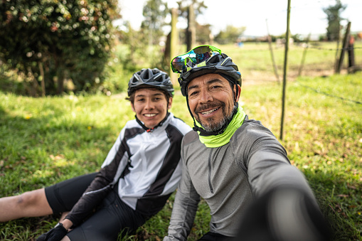 istock Cyclist father and son taking a selfie or filming in a rural place - camera point of view 1498754728