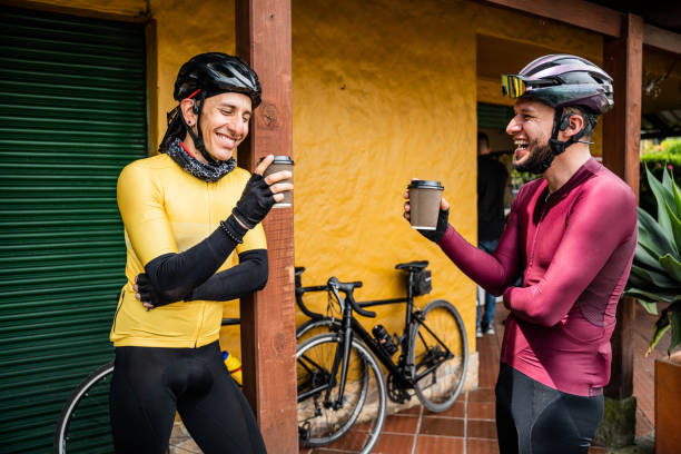 Cyclist men talking while drink a coffee in the city