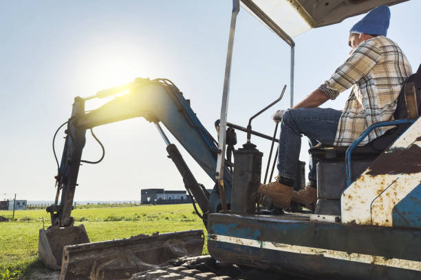 istock Young man operating his old excavator during his work on a construction site 1498758593