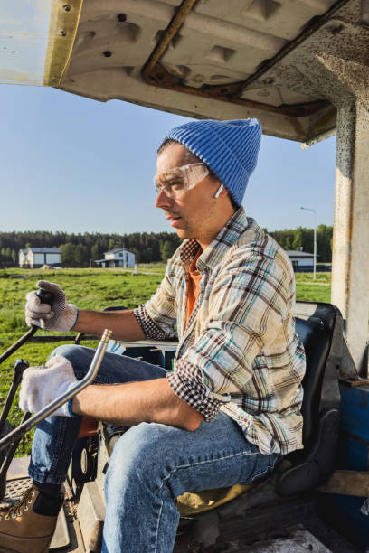 istock Young man operating his old excavator during his work on a construction site 1498758664