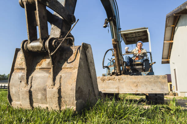 istock Young man operating his old excavator during his work on a construction site 1498758692