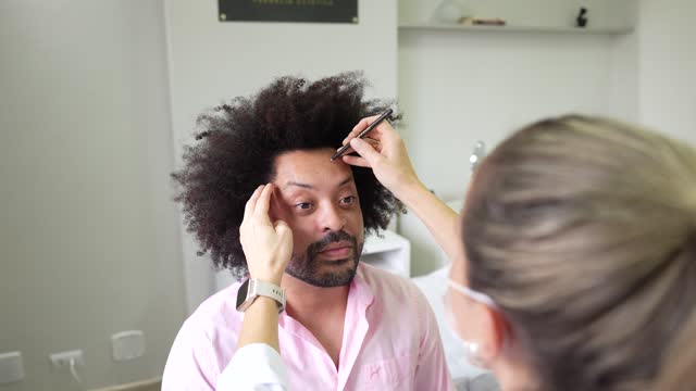 Man having his face marked before beauty procedures