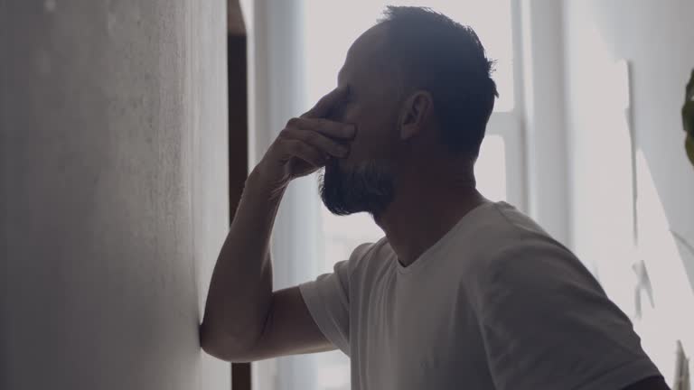 Depressed man in the hall. Rubbing the bridge of his nose