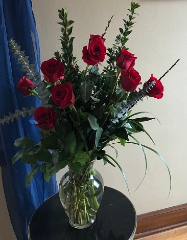 Delicate wedding bouquet of beige and red roses on a white leather armchair