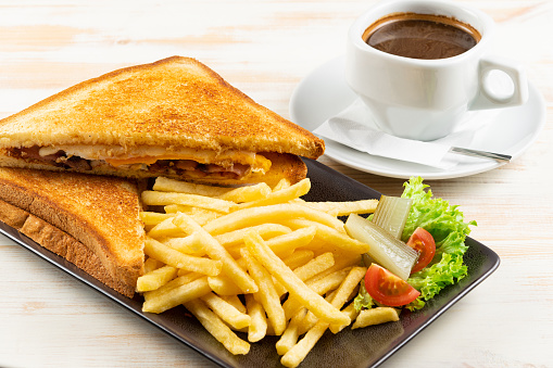 Îreakfast toast with bacon, cheese, pan fried potatoes and cup of coffee. Food background.