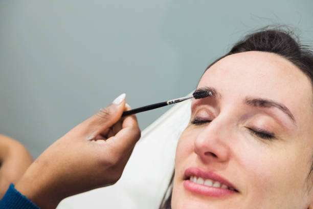 istock Caucasian woman removing hair from eyebrows with thread technique done by eyebrow stylist. Threading. Process Steps. Close up 1498770824