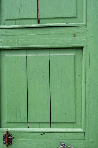 Beautiful green wood jalousie on windows of renovated old building.