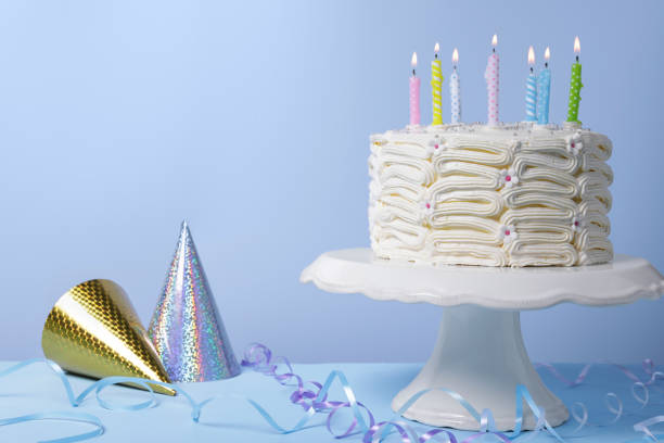 istock Delicious cake with burning candles and festive decor on light blue background. Space for text 1498781403