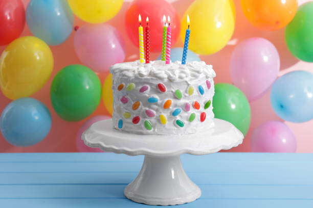 istock Delicious cake with cream and burning candles on light blue table 1498782004