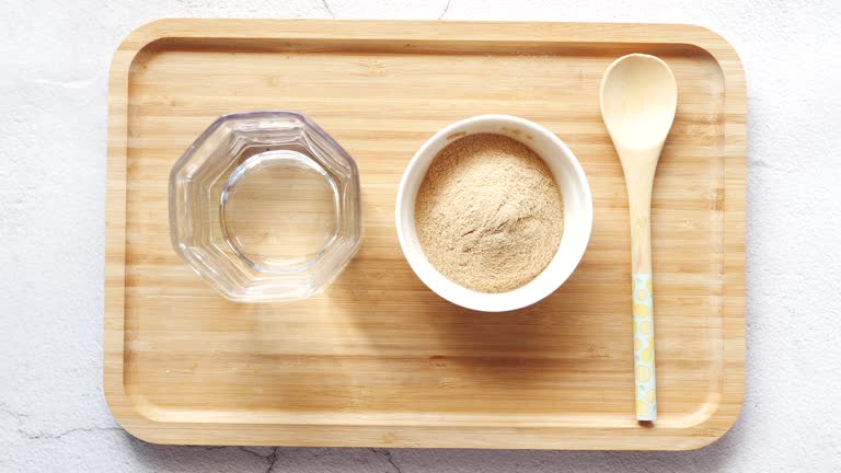 mixing brewers yeast flakes in a glass of water