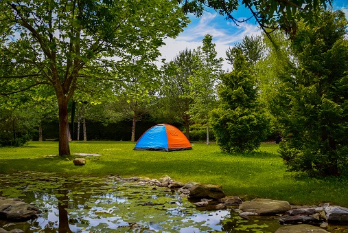 camping tent set up by the lake in the park forest