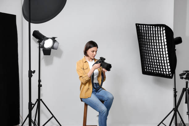 istock Professional photographer with camera in modern photo studio 1498786217