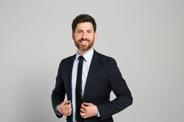 istock Handsome real estate agent in nice suit on grey background 1498786355
