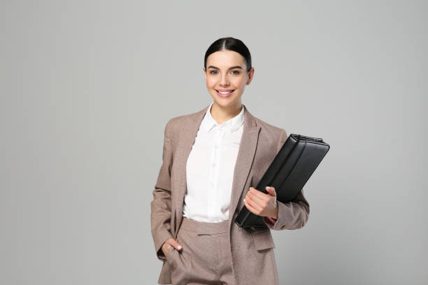 istock Beautiful real estate agent with documents on grey background 1498786392