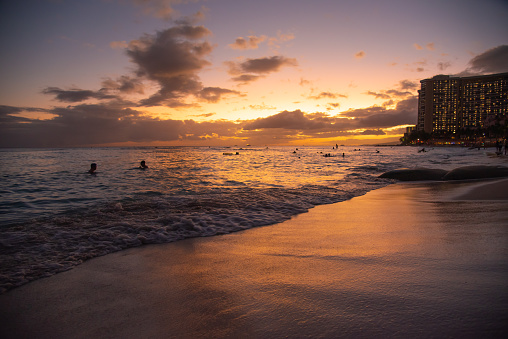 Incredible sunset at Waikiki Beach, Hawaii, USA with purple, orange and pink pastel colors in sky along stunning, pristine tourist area.