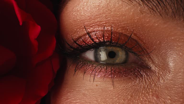 Macro woman eyes with vibrant make-up in roses flowers.Skin care, beauty concept