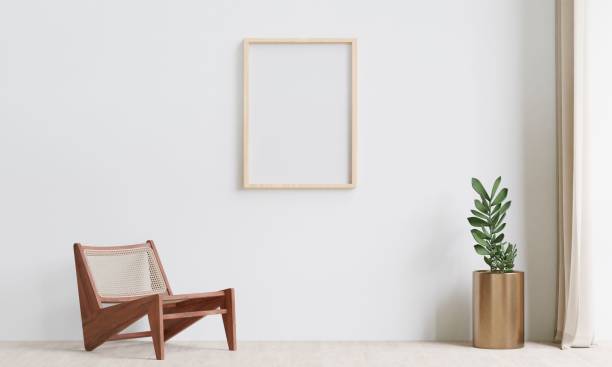 istock Wooden chair and an empty frame on a white wall in a luminous room. 3d rendering. 1498793426