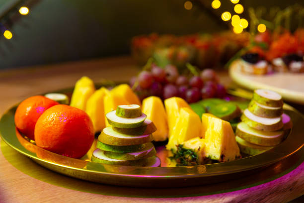 istock Fruit plate on the table, close-up, selective focus on sliced fruits: oranges, pineapple, pears, grapes 1498795468